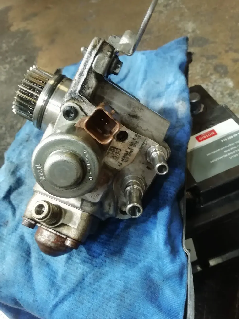 Pompe d'injection haute pression déposée sur l'établi du garage