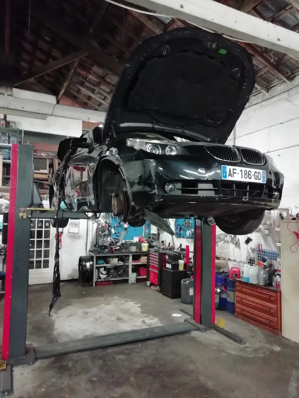 Berline levée capot ouvert pendant une réparation au garage Auto Express