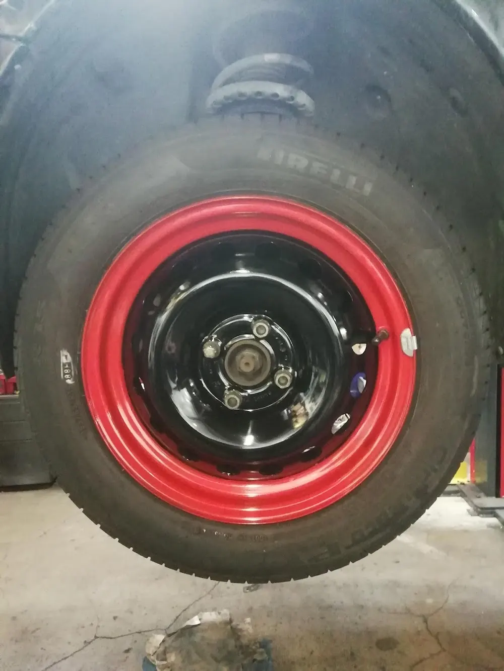 Roue avec jante tôle rouge montée au garage Auto Express