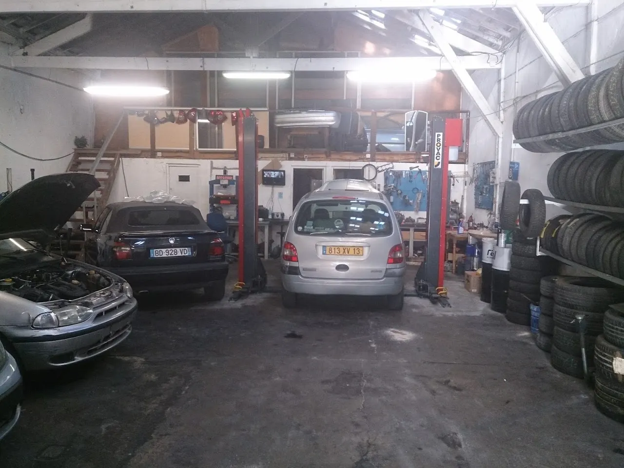 Atelier du garage Auto Express à Marseille 14e avec voitures sur ponts élévateurs et stock de pneus